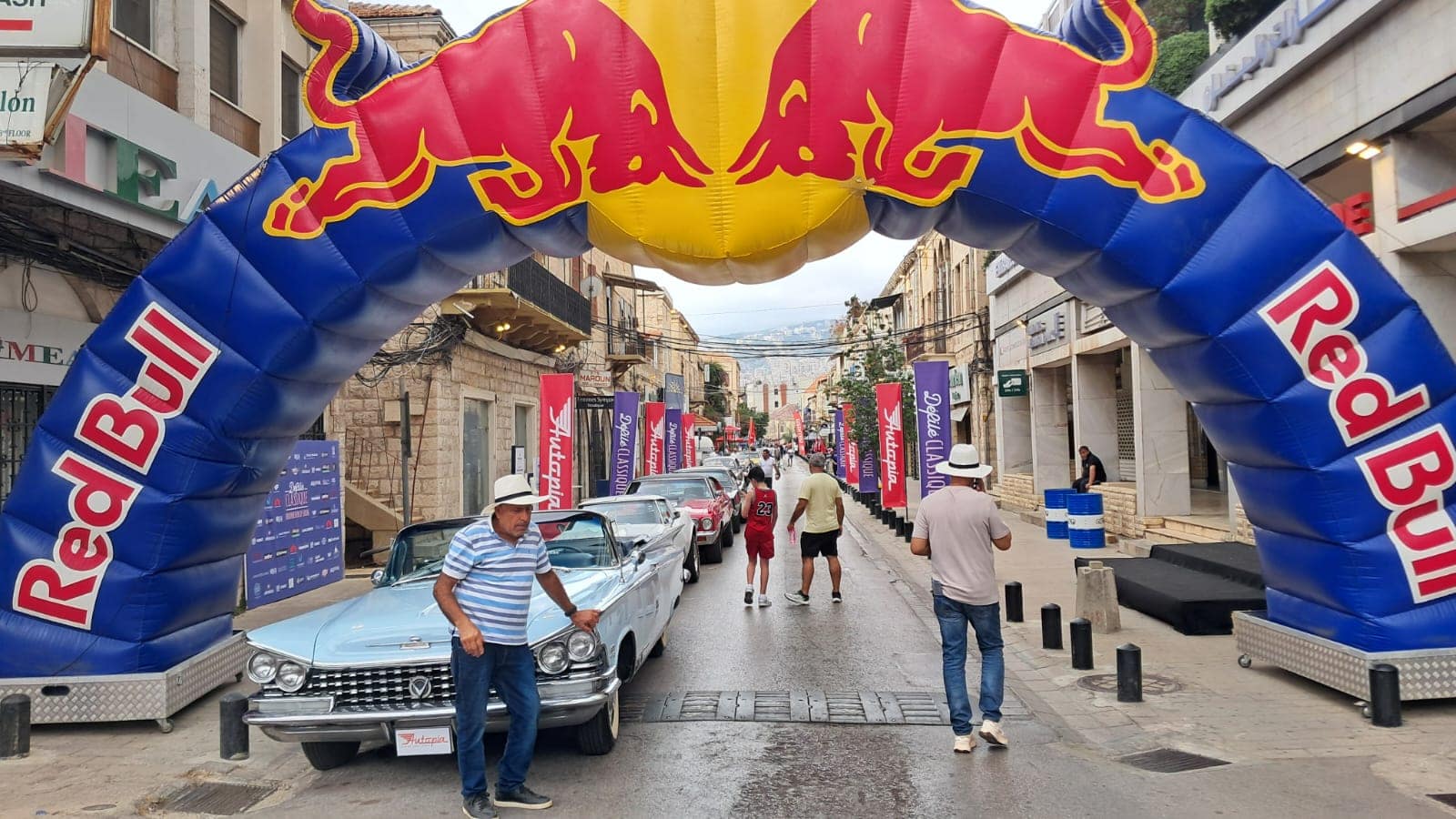 The parade rolling under the red arch into the souk, the crowd walking alongside