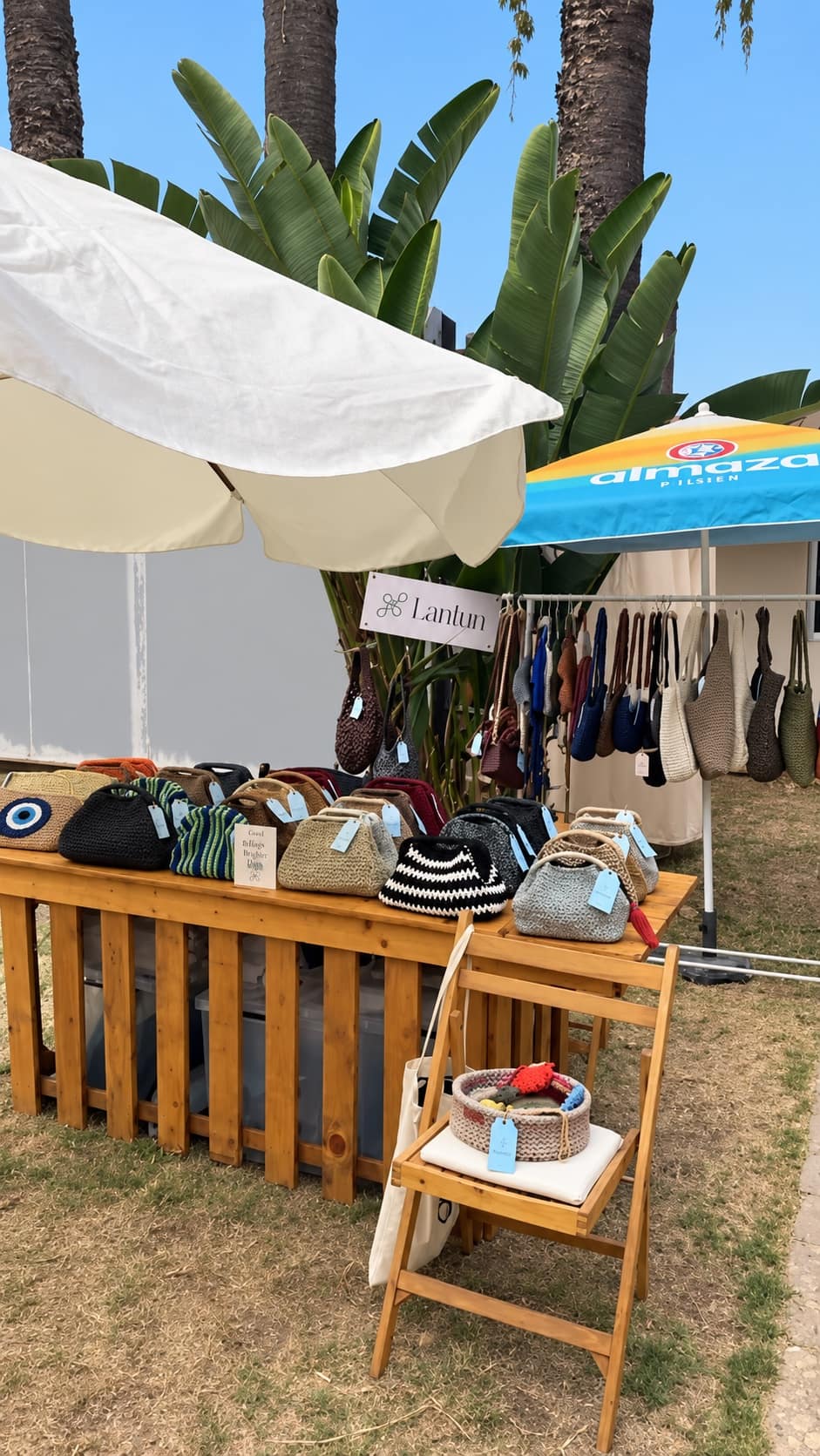 A designer stall at the market, woven bags on display under a white parasol