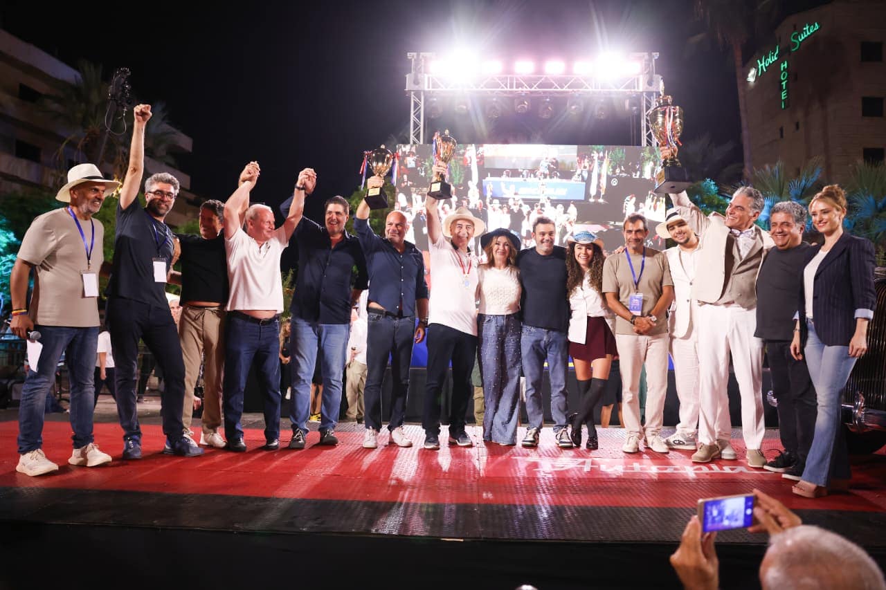 The winners and jury cheering together on the main stage under the lights