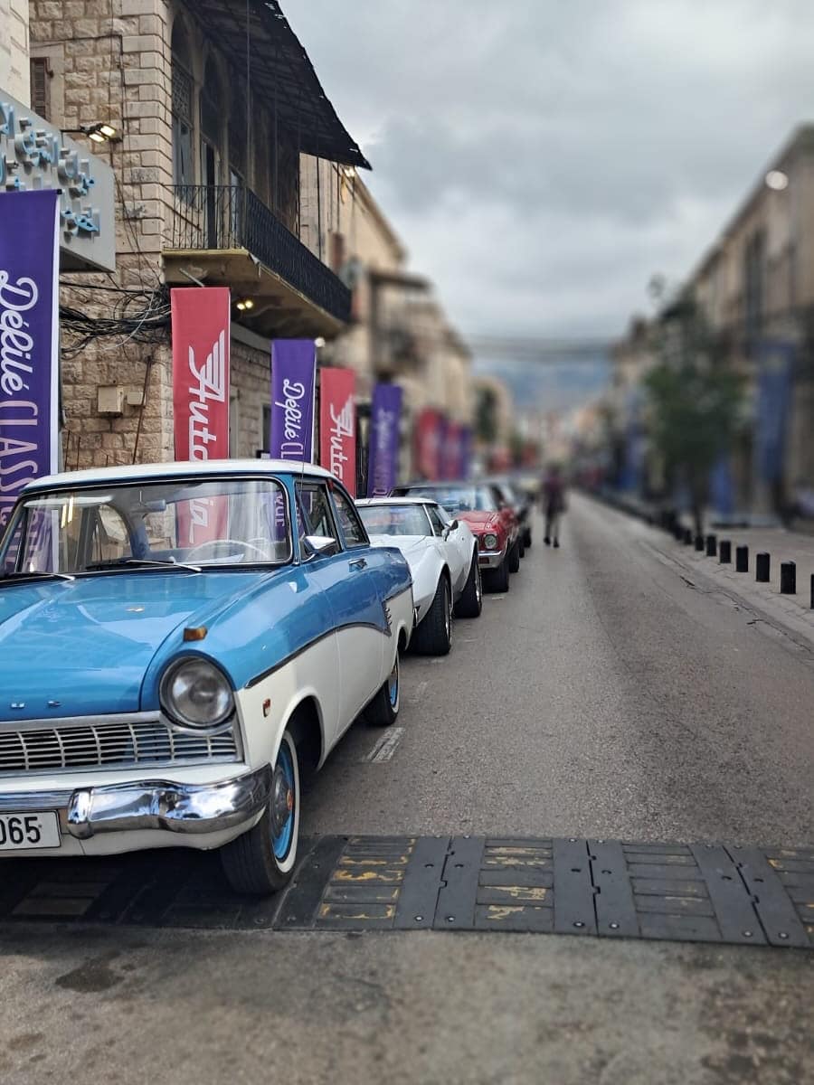 A blue and white 1950s Ford in the street