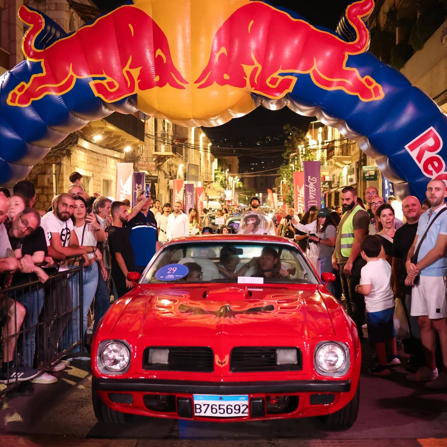 A red Pontiac in front of the crowd