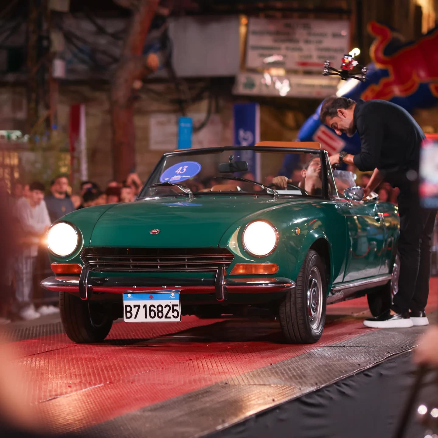 A green Fiat 124 spider on the stage