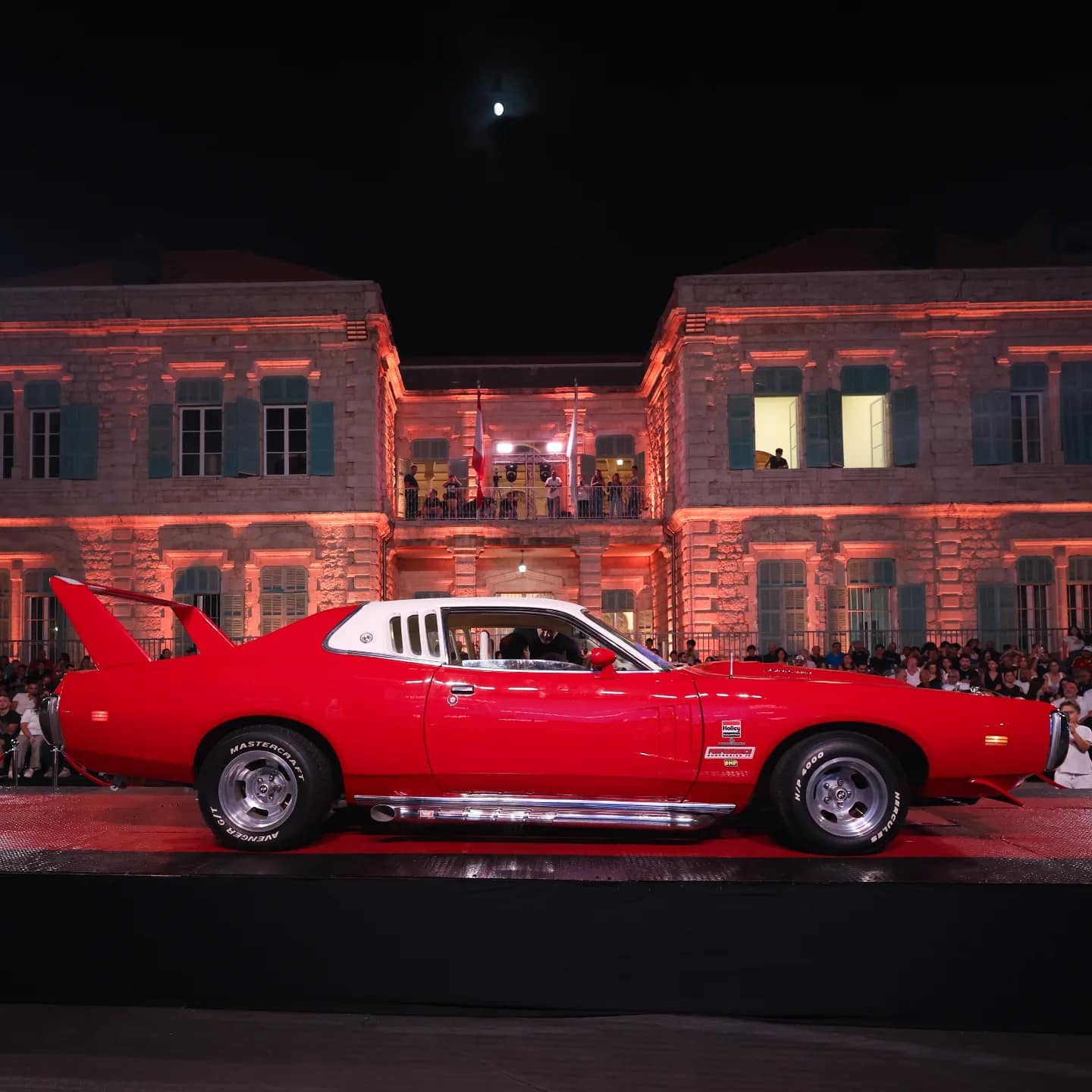 A red Plymouth Superbird on the red stage