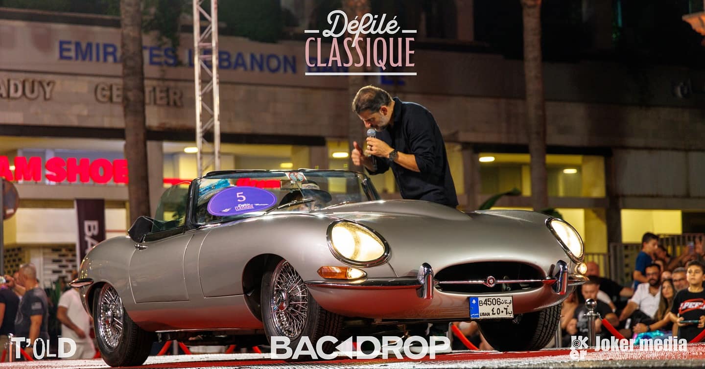 A silver 1967 Jaguar E-Type roadster on the stage