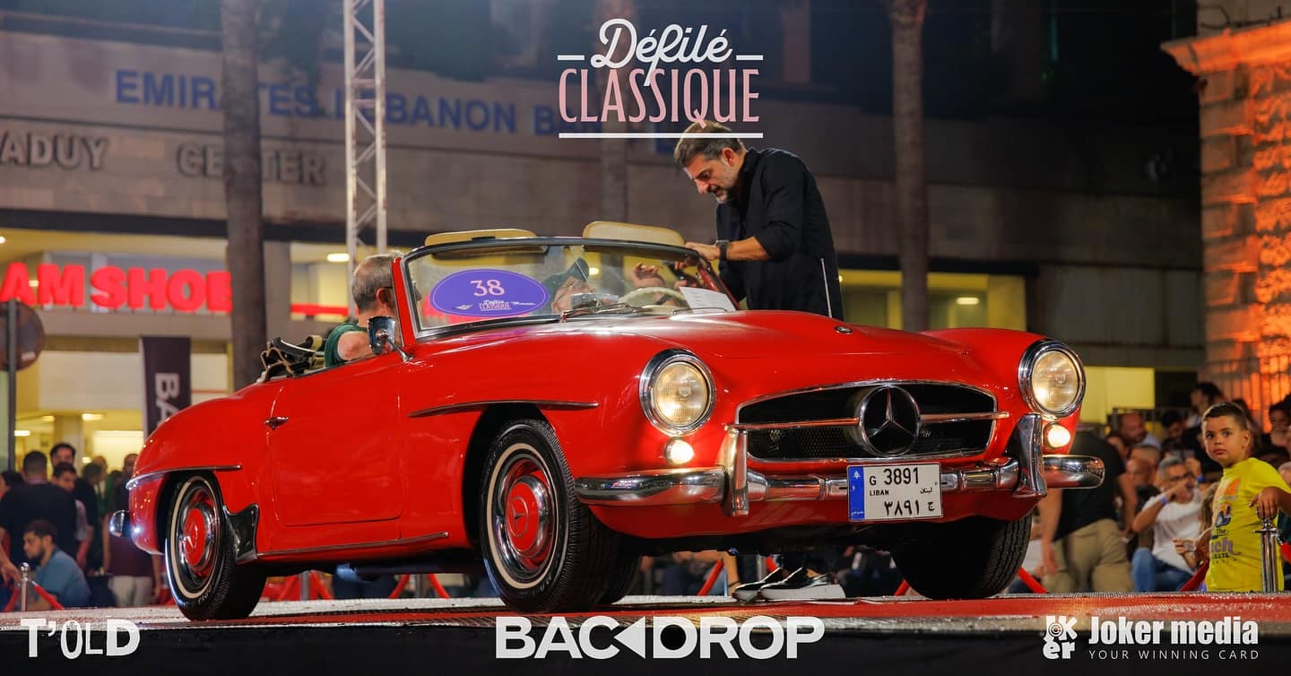 A red 1955 Mercedes 190SL roadster on the stage