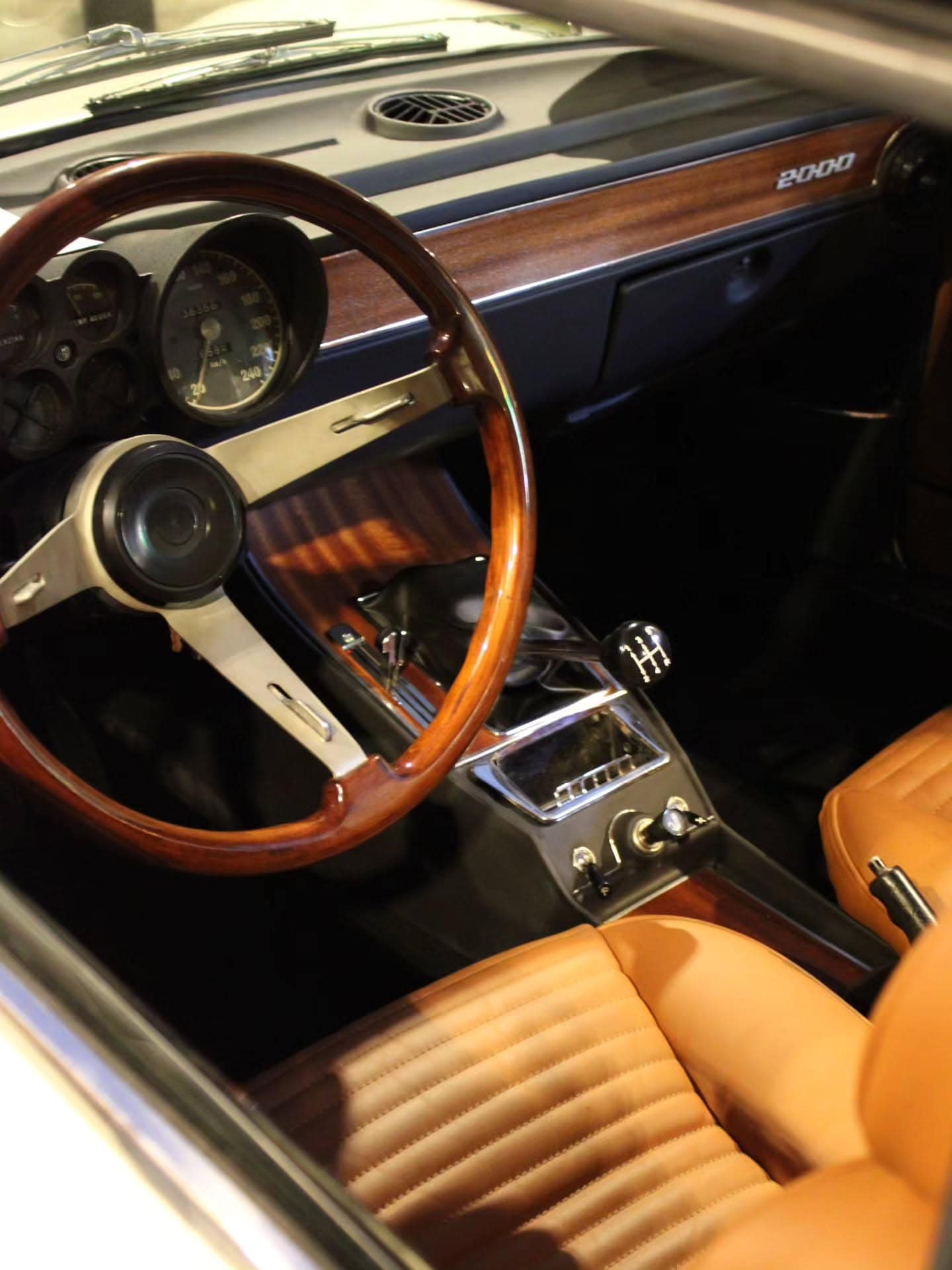 A wooden steering wheel and tan leather interior