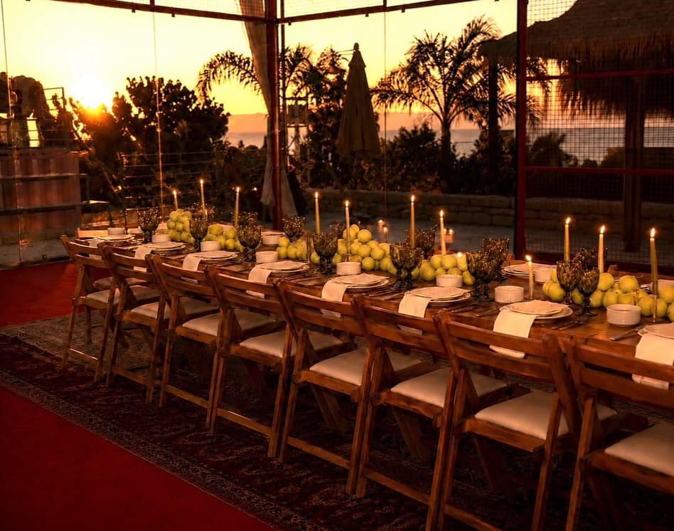One long table set on a padel court at sunset, the Courtside Supper Club